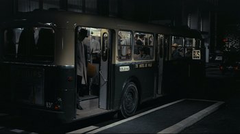 Movie still from “Playtime” (1967), directed by Jacques Tati – People are riding on a bus in the dark; Wide shot, High angle