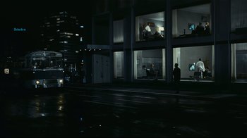 Movie still from “Playtime” (1967), directed by Jacques Tati – A man standing on the side of the road at night; Extreme Wide shot, High angle