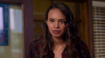 Movie still from “13 Reasons Why” (2017), created by Brian Yorkey – A woman with long brown curly hair wearing a red and black shirt; Close Up shot, Over the shoulder angle