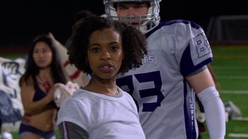 Movie still from “13 Reasons Why” (2017), created by Brian Yorkey – A young girl standing next to a man in a football uniform; Medium shot, Over the shoulder angle