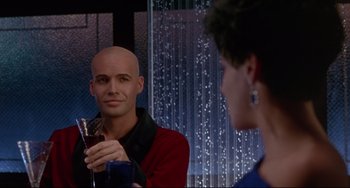 Movie still from “Poetic Justice” (1993), directed by John Singleton – A man with a bald head holding a glass of wine; Medium shot, Over the shoulder angle