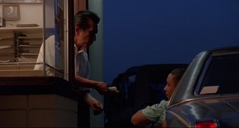 Movie still from “Poetic Justice” (1993), directed by John Singleton – A man is handing something to a child; Medium shot, Over the shoulder angle