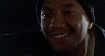 Movie still from “Poetic Justice” (1993), directed by John Singleton – A man smiling for the camera; Close Up shot, Over the shoulder angle