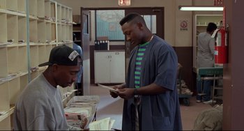 Movie still from “Poetic Justice” (1993), directed by John Singleton – A man is looking at papers in a book store; Medium shot, Over the shoulder angle