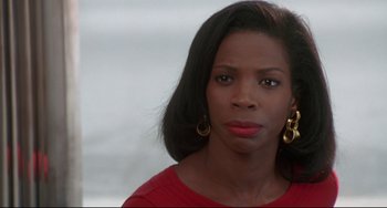 Movie still from “Poetic Justice” (1993), directed by John Singleton – A black woman wearing a red shirt and gold earrings; Close Up shot, Over the shoulder angle