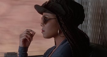 Movie still from “Poetic Justice” (1993), directed by John Singleton – A woman with braids and a hat looking out a window; Close Up shot, Over the shoulder angle