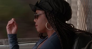 Movie still from “Poetic Justice” (1993), directed by John Singleton – A woman wearing a hat and sunglasses with her hair pulled back; Close Up shot, Over the shoulder angle