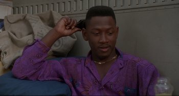 Movie still from “Poetic Justice” (1993), directed by John Singleton – A man in a purple shirt combing his hair; Close Up shot, Low angle