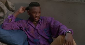 Movie still from “Poetic Justice” (1993), directed by John Singleton – A man sitting on a couch wearing a purple shirt; Close Up shot, High angle