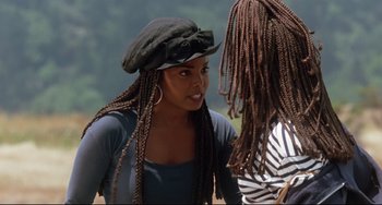 Movie still from “Poetic Justice” (1993), directed by John Singleton – A woman wearing a hat with long braids talking to another woman; Close Up shot, Over the shoulder angle