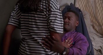 Movie still from “Poetic Justice” (1993), directed by John Singleton – A man in a purple shirt is hugging another man; Medium shot, High angle