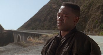 Movie still from “Poetic Justice” (1993), directed by John Singleton – A man standing in front of a mountain with his eyes wide open; Close Up shot, Low angle