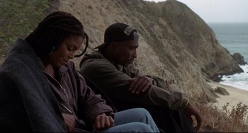 Movie still from “Poetic Justice” (1993), directed by John Singleton – A man and a woman sitting next to each other on a cliff; Medium shot, Low angle