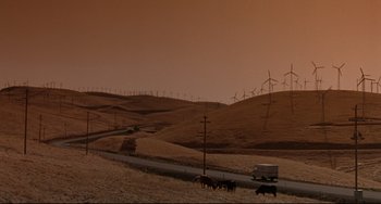 Movie still from “Poetic Justice” (1993), directed by John Singleton – A truck driving down a dirt road next to a wind farm; Extreme Wide shot, Low angle