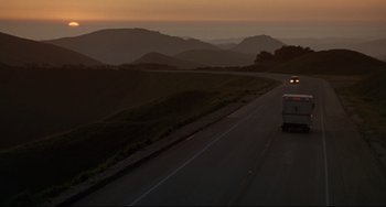 Movie still from “Poetic Justice” (1993), directed by John Singleton – A bus driving down a road near a mountain range; Extreme Wide shot, Low angle