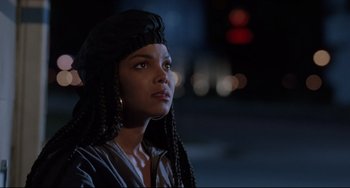 Movie still from “Poetic Justice” (1993), directed by John Singleton – A woman with long black hair wearing a black headpiece; Close Up shot, Over the shoulder angle