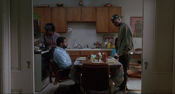 Movie still from “Poetic Justice” (1993), directed by John Singleton – A group of people standing around a table in a kitchen; Wide shot, High angle
