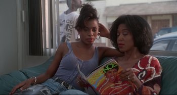 Movie still from “Poetic Justice” (1993), directed by John Singleton – Two women sitting next to each other and reading a magazine; Medium shot, High angle
