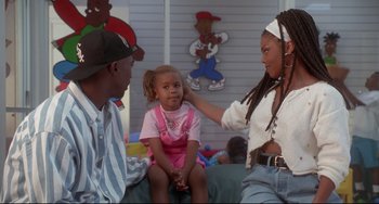 Movie still from “Poetic Justice” (1993), directed by John Singleton – A young girl sitting between two adults in a room; Medium shot, Over the shoulder angle