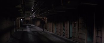 Movie still from “Point Blank” (1967), directed by John Boorman – A man walking down a hallway in a jail cell at night; Extreme Wide shot, High angle