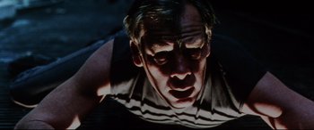 Movie still from “Point Blank” (1967), directed by John Boorman – A man's face in the dark; Close Up shot, Low angle