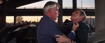 Movie still from “Point Blank” (1967), directed by John Boorman – An older man in a suit and tie hugging another older man; Close Up shot, Over the shoulder angle