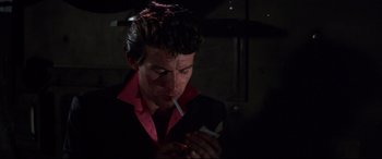 Movie still from “Point Blank” (1967), directed by John Boorman – A man smoking a cigarette while holding a cell phone; Close Up shot, Low angle