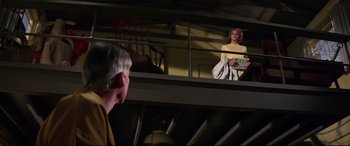 Movie still from “Point Blank” (1967), directed by John Boorman – An older man and a young woman are standing on a balcony; Wide shot, Low angle