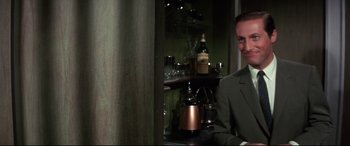 Movie still from “Point Blank” (1967), directed by John Boorman – A man in a suit and tie in front of a bar; Medium shot, Over the shoulder angle
