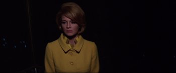 Movie still from “Point Blank” (1967), directed by John Boorman – A woman wearing a yellow coat standing in the dark; Medium shot, Low angle