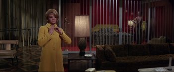 Movie still from “Point Blank” (1967), directed by John Boorman – A woman standing in a living room next to a lamp; Medium shot, Low angle