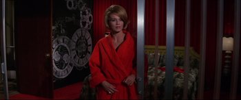 Movie still from “Point Blank” (1967), directed by John Boorman – A woman in a red bathrobe standing next to a door; Medium shot, Low angle