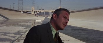 Movie still from “Point Blank” (1967), directed by John Boorman – A man in a suit and tie with blood all over his face; Close Up shot, Over the shoulder angle