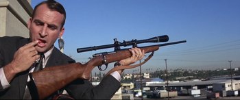 Movie still from “Point Blank” (1967), directed by John Boorman – A man holding a rifle with a scope; Medium shot, Low angle