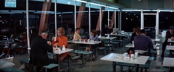Movie still from “Point Blank” (1967), directed by John Boorman – A group of people sitting at tables in a restaurant; Wide shot, High angle
