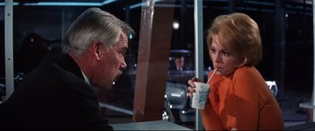 Movie still from “Point Blank” (1967), directed by John Boorman – A man and a woman sitting at a table; Medium shot, Over the shoulder angle