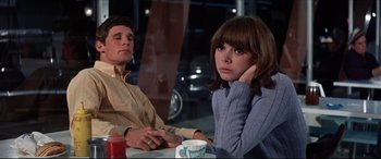 Movie still from “Point Blank” (1967), directed by John Boorman – A man and a woman sitting at a table; Medium shot, High angle