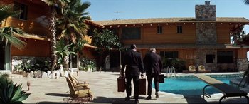 Movie still from “Point Blank” (1967), directed by John Boorman – Two men in business suits are walking by a pool; Wide shot, High angle