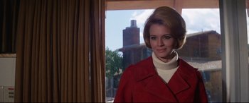 Movie still from “Point Blank” (1967), directed by John Boorman – A woman in a red coat standing in front of a window; Close Up shot, Low angle