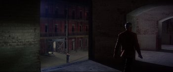 Movie still from “Point Blank” (1967), directed by John Boorman – A man standing on a ledge in front of a building; Extreme Wide shot, High angle
