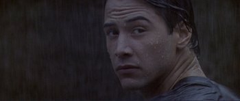 Movie still from “Point Break” (1991), directed by Kathryn Bigelow – A man's face in the rain; Close Up shot, Over the shoulder angle