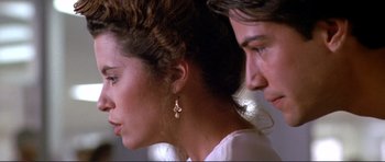 Movie still from “Point Break” (1991), directed by Kathryn Bigelow – A man and a woman looking at each other; Close Up shot, Over the shoulder angle