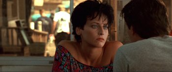 Movie still from “Point Break” (1991), directed by Kathryn Bigelow – A person with short black hair; Close Up shot, Over the shoulder angle