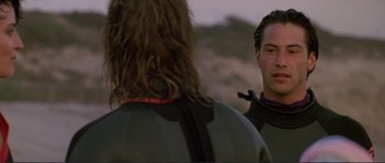Movie still from “Point Break” (1991), directed by Kathryn Bigelow – A man in a black jacket is looking at another man in a black jacket; Close Up shot, Over the shoulder angle