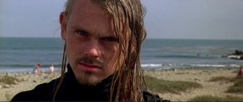 Movie still from “Point Break” (1991), directed by Kathryn Bigelow – A person with wet hair on the beach; Close Up shot, Low angle