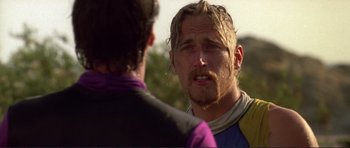 Movie still from “Point Break” (1991), directed by Kathryn Bigelow – A man with long hair is talking to another man; Close Up shot, Over the shoulder angle