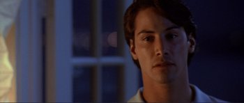 Movie still from “Point Break” (1991), directed by Kathryn Bigelow – A man's face in front of a window at night; Close Up shot, Over the shoulder angle