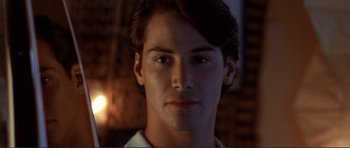 Movie still from “Point Break” (1991), directed by Kathryn Bigelow – A young man's face at night; Close Up shot, Over the shoulder angle