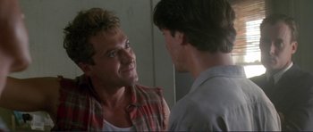 Movie still from “Point Break” (1991), directed by Kathryn Bigelow – Two men talking to each other in front of a mirror; Close Up shot, Over the shoulder angle