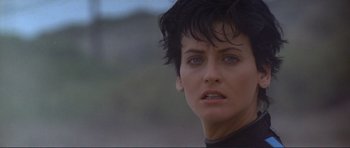 Movie still from “Point Break” (1991), directed by Kathryn Bigelow – A person with short black hair; Close Up shot, Low angle